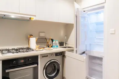 a kitchen with a stove and a washing machine at Stylish 1 BHK in Damac Zada Tower, Business Bay in Dubai
