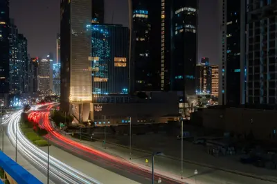 a city skyline at night with traffic on a highway at Stylish 1 BHK in Damac Zada Tower, Business Bay in Dubai