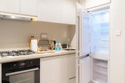 a kitchen with white cabinets and a stove top oven at Stylish 1 BHK in Damac Zada Tower, Business Bay in Dubai