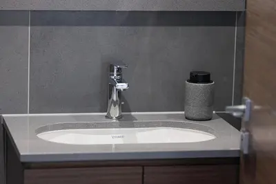 a bathroom sink with a faucet on a counter at Moon Stays - Opulent 2BR Stay - Sobha Hartland in Dubai