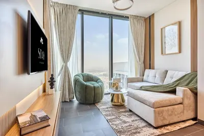 a living room with a couch and a large window at STAY BY LATINEM Luxury 1BR Holiday Home CB 3503 Near Downtown in Dubai