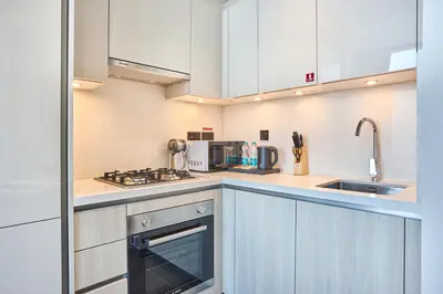a kitchen with white cabinets and a sink at STAY BY LATINEM Luxury 1BR Holiday Home CB 3503 Near Downtown in Dubai