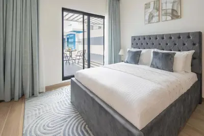 a bedroom with a large bed and a balcony at Frank Porter - Santorini 1, Damac Lagoons in Dubai