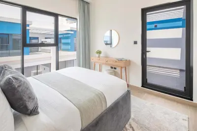 a bedroom with a bed and a large window at Frank Porter - Santorini 1, Damac Lagoons in Dubai