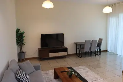 a living room with a couch and a tv and a table at Spacious 1 BR in Sulafa Tower in Dubai