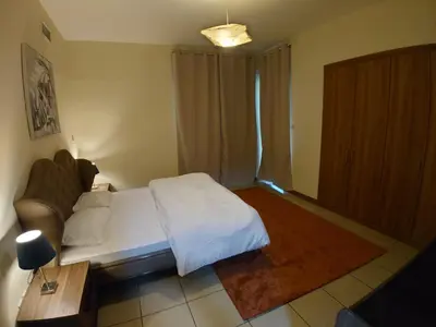 a bedroom with a white bed and a couch at Spacious 1 BR in Sulafa Tower in Dubai