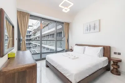 a bedroom with a bed and a large window at Elegant 2BR Apartment Private Pool by Czechin in Dubai