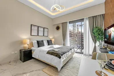 a bedroom with a bed and a large window at Fully-Equipped Studio with Pool, Gym & Chic Location in Dubai