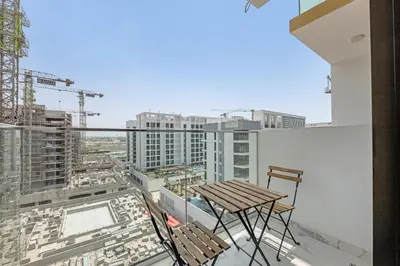 a balcony with a table and chairs on a building at Fully-Equipped Studio with Pool, Gym & Chic Location in Dubai
