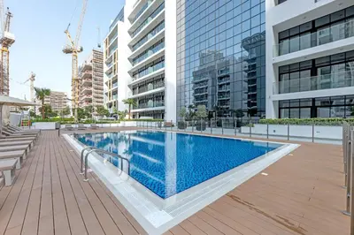a swimming pool in a building with tall buildings at Fully-Equipped Studio with Pool, Gym & Chic Location in Dubai
