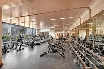 a gym with rows of chairs and tread machines at Fully-Equipped Studio with Pool, Gym & Chic Location in Dubai