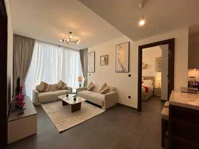 a living room with two couches and a bedroom at The Crest Sobha Hartland in Dubai