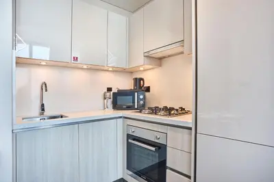 a kitchen with white cabinets and a microwave at STAY BY LATINEM Luxury 1BR Holiday Home CB1508 Near Burj Khalifa in Dubai