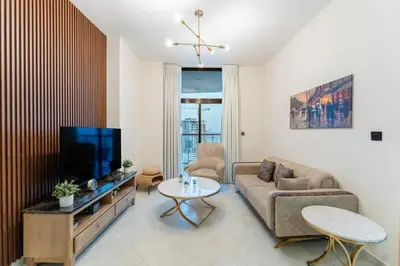 a living room with a couch and a tv at Cosy 2 Bed Apartment in Al Jaddaf in Dubai