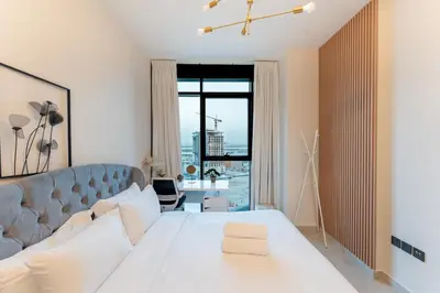 a bedroom with a white bed and a large window at Cosy 2 Bed Apartment in Al Jaddaf in Dubai