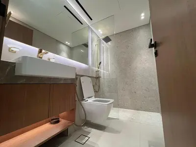 a bathroom with a toilet and a sink and a mirror at Binghatti Lavender in Dubai