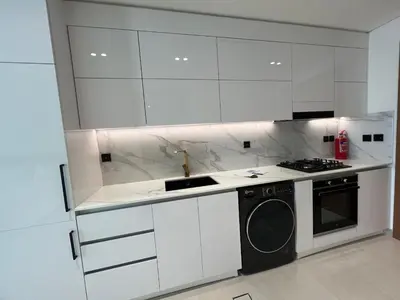 a white kitchen with a stove and a washing machine at Binghatti Lavender in Dubai