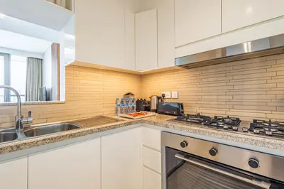a kitchen with a sink and a stove top oven at Superhost- Elegant Downtown 3BR , Burj Khalifa View in Dubai
