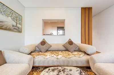 a living room with a couch and a mirror at Superhost- Elegant Downtown 3BR , Burj Khalifa View in Dubai