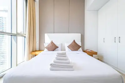 a bedroom with a white bed with towels on it at Superhost- Elegant Downtown 3BR , Burj Khalifa View in Dubai