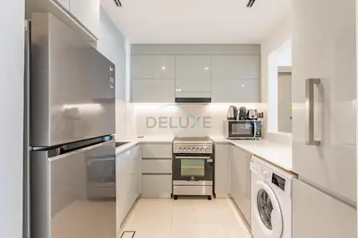 a kitchen with a stove top oven next to a dishwasher at Trendy 1BR with a Glimpse of Burj Khalifa, Near Zabeel Stadium, Minutes Drive to Dubai Frame, Binghatti Creek, Al Jaddaf by Deluxe Holiday Homes in Dubai