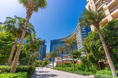 a street with palm trees in front of buildings at Palm Jumeirah, panoramic free pool,beach in Dubai
