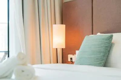a bed with a lamp next to a window at Palm Jumeirah, panoramic free pool,beach in Dubai