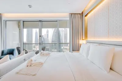 a large white bed in a room with a large window at PVH - Emaar Residence Fashion Avenue - Burj Khalifa View Studio in Dubai