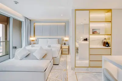 a bedroom with two beds and a living room at PVH - Emaar Residence Fashion Avenue - Burj Khalifa View Studio in Dubai