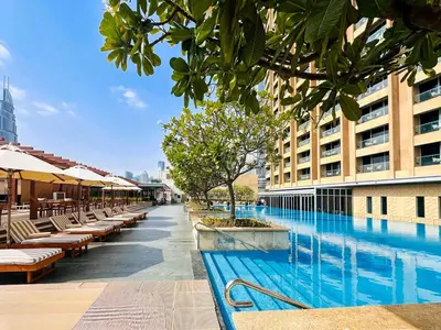a swimming pool with tables and chairs next to a building at PVH - Emaar Residence Fashion Avenue - Burj Khalifa View Studio in Dubai