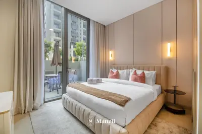 a bedroom with a large bed and a balcony at Waterfront 1BR Apartment in Creek Harbour near Downtown in Dubai