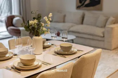 a dining room table with plates and wine glasses at Waterfront 1BR Apartment in Creek Harbour near Downtown in Dubai
