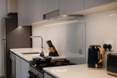 a kitchen with a stove and a counter top at Waterfront 1BR Apartment in Creek Harbour near Downtown in Dubai