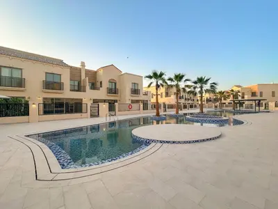 a pool in a courtyard with palm trees and buildings at FIRST CLASS VILLA Hidden Luxury Gem in Dubai