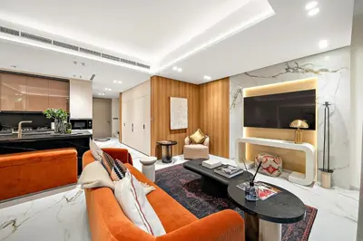 a living room with an orange couch and a table at FIRST CLASS VILLA Hidden Luxury Gem in Dubai