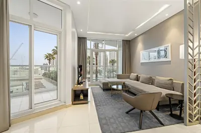 a living room with a couch and a large window at Spacious 1BR with Balcony and Pool Access in Dubai