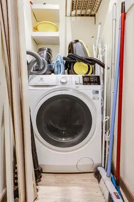 a washing machine in a small room with skis at FIRST CLASS 2BR Luxe & Lively Living in Dubai