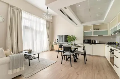 a kitchen and living room with a table and chairs at FIRST CLASS 2BR Luxe & Lively Living in Dubai