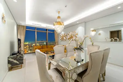a dining room with a glass table and chairs at Luxe 2BR at Paramount l High Floor with Infinity Pool in Dubai