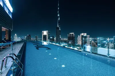 a rooftop swimming pool with a view of a city at Luxe 2BR at Paramount l High Floor with Infinity Pool in Dubai