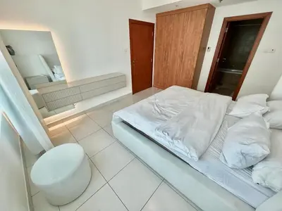 a white bed in a room with a mirror at Marina Walk View Luxury 1BR close to JBR beach! in Dubai
