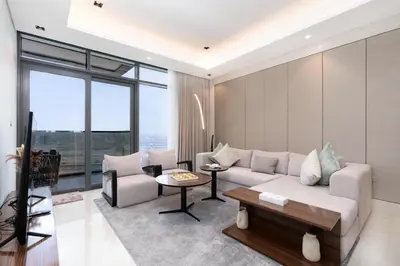 a living room with a couch and a table at Samaya Holiday Homes - Modern Luxe Apartments - Nobles Tower in Dubai