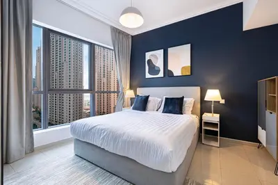 a bedroom with a large bed and a large window at Modern 1BR Apt With Access to Jacuzzi, Sauna & Pool in Dubai