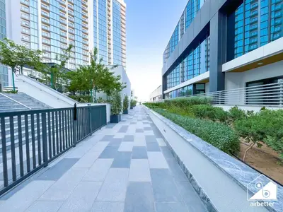 a walkway in a city with tall buildings at Luxury 1-Bed in Meydan with Balcony & City Views in Dubai