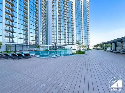 a large apartment building with a large swimming pool at Premium 1BR Retreat, Balcony Bliss, Pool & Gym in Dubai