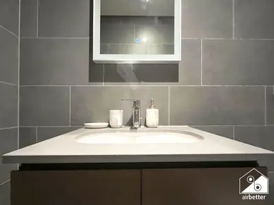 a bathroom with a sink and a mirror at Premium 1BR Retreat, Balcony Bliss, Pool & Gym in Dubai