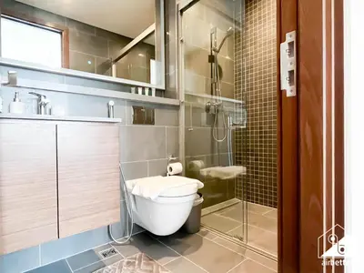 a bathroom with a toilet and a glass shower at Premium 1BR Retreat, Balcony Bliss, Pool & Gym in Dubai