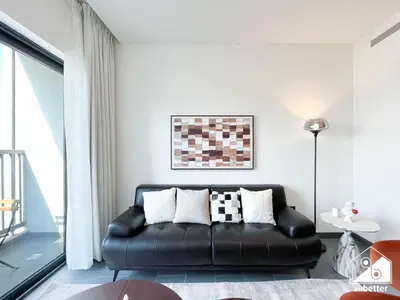 a living room with a black leather couch at Premium 1BR Retreat, Balcony Bliss, Pool & Gym in Dubai