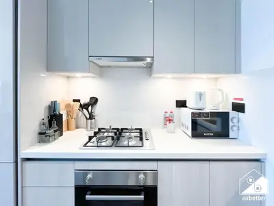 a kitchen with a stove and a microwave at Modern 1B Luxury , Scenic City Balcony, Pool & Gym in Dubai