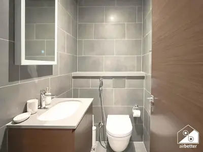 a bathroom with a white toilet and a sink at Modern 1B Luxury , Scenic City Balcony, Pool & Gym in Dubai
